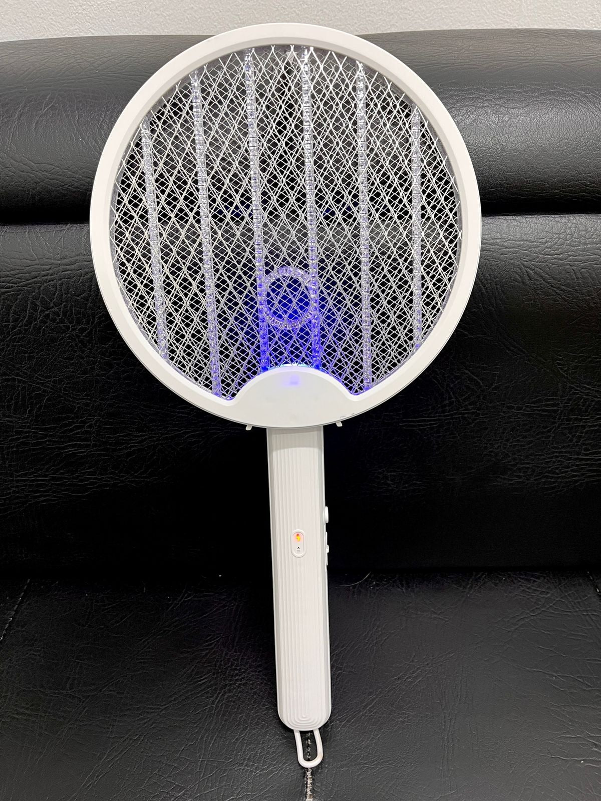 Raqueta mata zancudos plegable con la luz morada encendida